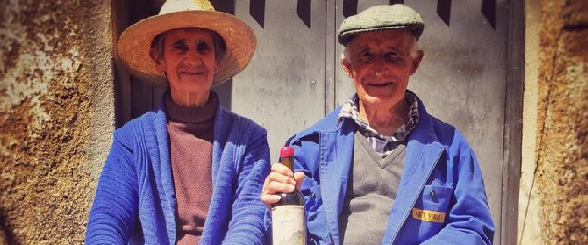 Fotografía de una mujer y un hombre de avanzada edad con una de las botellas de maquina y tabla